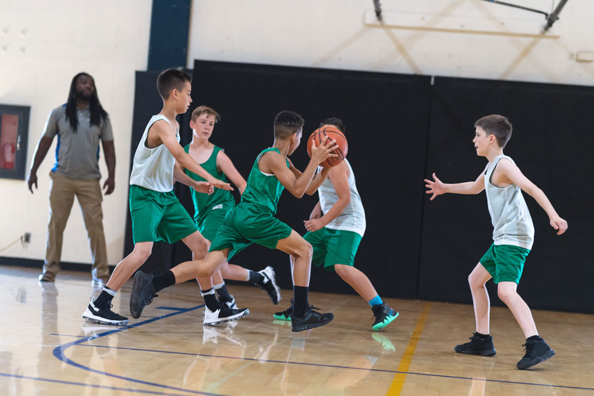 youth basketball team players in green and white uniforms